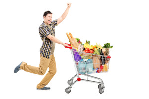 Full length portrait of a happy man pushing a shopping cart
